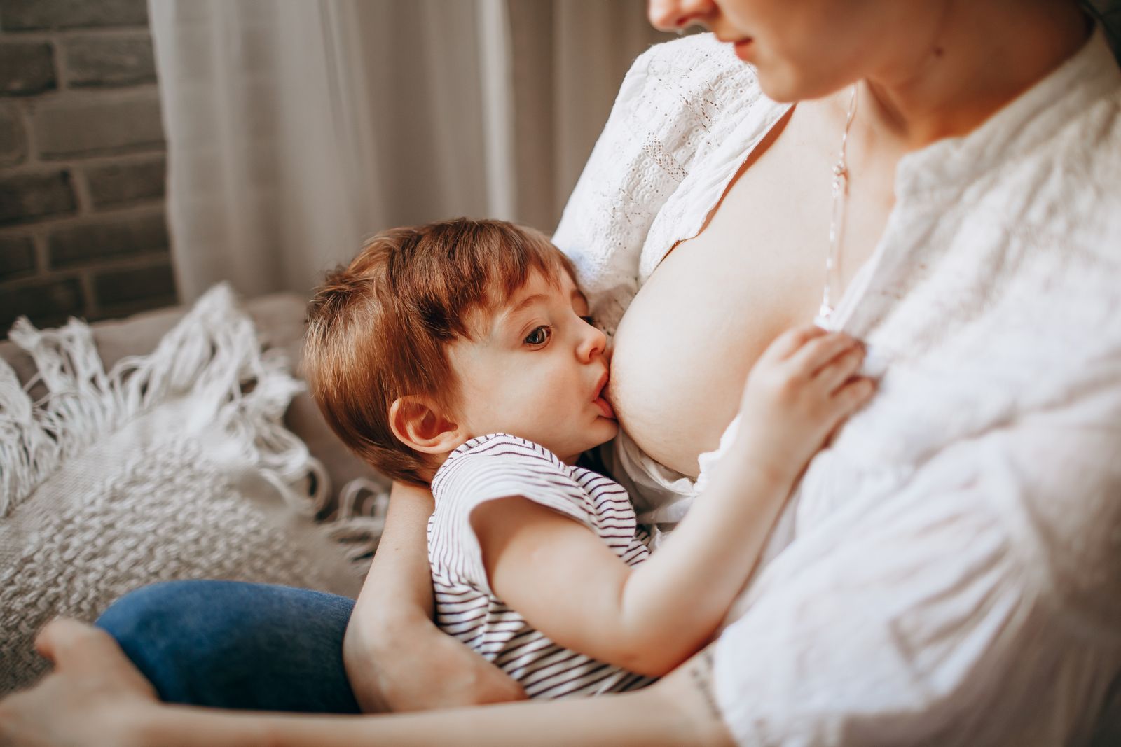 Mamma che allatta il suo bambino in un ambiente semplice e raccolto
